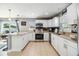Well-lit kitchen featuring white cabinets, granite countertops, stainless steel appliances, and backyard access at 4523 Oakglen Rd, Lakeland, FL 33813