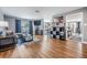 Living room featuring hardwood floors, a modern sofa, and open access to the kitchen and dining areas at 4523 Oakglen Rd, Lakeland, FL 33813