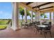 Spacious patio with multiple tables, chairs, columns, and beautiful golf course views at 4764 Waltham Forest Dr, Davenport, FL 33837