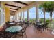 Covered patio area with ample seating overlooking a beautiful golf course and palm trees at 4779 Waltham Forest Dr, Davenport, FL 33837
