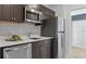A well-equipped kitchen featuring stainless steel appliances, granite countertops, and dark wood cabinets at 466 Puma Loop, Groveland, FL 34736