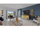 Spacious living room with a dark accent wall, modern furniture, and sliding glass door to the backyard at 466 Puma Loop, Groveland, FL 34736