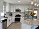 Bright kitchen featuring granite countertops, stainless appliances, and white cabinetry at 620 San Pedro Dr, Lady Lake, FL 32159