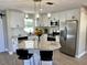 Well-lit kitchen featuring granite countertops, stainless appliances, and an island with breakfast bar seating at 620 San Pedro Dr, Lady Lake, FL 32159