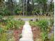 Charming walkway leading to the home, adorned with lush greenery and vibrant flowers at 109 Fern Dr, Debary, FL 32713