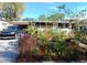 Charming home exterior featuring a beautiful front yard garden and a car parked in the carport at 109 Fern Dr, Debary, FL 32713