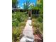 Inviting walkway leading to a charming home exterior with lush landscaping and blooming flowers at 109 Fern Dr, Debary, FL 32713