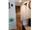 Hallway view leading to bedroom with hardwood-style floors, floral wall decor and neutral tones at 109 Fern Dr, Debary, FL 32713