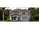 Two-story home showcases a front yard with a mix of green bushes and well-maintained landscaping at 3235 Armstrong Ave, Clermont, FL 34714