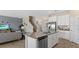 Modern kitchen with white cabinets, stainless appliances, gray countertops, and an adjacent living room at 3235 Armstrong Ave, Clermont, FL 34714