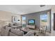 Modern living room with gray walls, neutral furniture, carpet flooring, and bright natural light at 3235 Armstrong Ave, Clermont, FL 34714