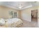 Bedroom featuring tray ceilings, neutral walls, plush carpeting, and a sunny window at 4530 Old Road 37, Lakeland, FL 33813