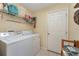 Functional laundry room with washer, dryer, shelving and tile floors at 4530 Old Road 37, Lakeland, FL 33813