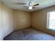 Bedroom featuring a ceiling fan and window with an old dark carpet at 1124 Liberty Hall Dr, Kissimmee, FL 34746