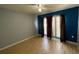 Bedroom featuring grey and blue walls, bamboo flooring, fan and large window with curtains at 1124 Liberty Hall Dr, Kissimmee, FL 34746