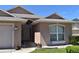 Inviting home exterior with manicured lawn, arched window, and security system visible at 1124 Liberty Hall Dr, Kissimmee, FL 34746