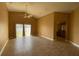 Spacious living room with vaulted ceiling, neutral tile, and sliding glass doors at 1124 Liberty Hall Dr, Kissimmee, FL 34746