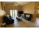 Comfortable living room featuring tile floors, ceiling fan, and dark leather furniture at 1124 Liberty Hall Dr, Kissimmee, FL 34746