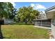 Expansive backyard showcases a shed, a screened-in porch, and mature trees, creating a serene outdoor space at 1203 Lake Miriam Dr, Lakeland, FL 33813