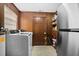 Functional laundry room equipped with a washer, dryer, storage shelves, and a stainless steel refrigerator at 1203 Lake Miriam Dr, Lakeland, FL 33813