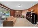 Cozy living room with wood paneling features a brick fireplace and sliding glass doors leading to the backyard at 1203 Lake Miriam Dr, Lakeland, FL 33813