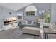 Airy living room bathed in natural light from its large arched window, featuring stylish gray sofas and modern decor at 5005 Laguna Bay Cir # 18, Kissimmee, FL 34746