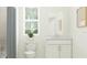 Clean bathroom with a white vanity, toilet, shower with grey curtain, and window at 4341 Curacao Pl, Kissimmee, FL 34758