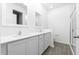 Bright bathroom featuring double vanity with white cabinets and countertop, framed mirrors, and glass-enclosed shower at 13430 Leaping Water Way, Astatula, FL 34705
