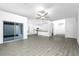 Spacious living area with modern gray wood-look flooring and a view into the bright kitchen at 13430 Leaping Water Way, Astatula, FL 34705