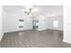 Bright living room featuring modern gray wood-look flooring, ample natural light and a ceiling fan at 13430 Leaping Water Way, Astatula, FL 34705