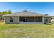 A house with gray roof tiles and a screened in porch and large backyard at 13581 Sw 48Th Ct, Ocala, FL 34473