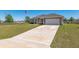 Home with a two-car garage, long driveway and sprawling green lawn at 13581 Sw 48Th Ct, Ocala, FL 34473
