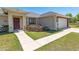 Charming home showcasing well-maintained landscaping, a driveway, and inviting entryway at 13581 Sw 48Th Ct, Ocala, FL 34473