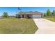 Well-maintained home with a two-car garage, long driveway and sprawling green lawn at 13581 Sw 48Th Ct, Ocala, FL 34473