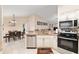 Open-concept kitchen with stainless appliances, granite counters, and seamless flow to dining area at 13581 Sw 48Th Ct, Ocala, FL 34473
