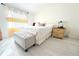 Bright bedroom with white walls and light wood floors featuring a plush bed and bedside table at 2514 Sea Oats N Cir, Lakeland, FL 33815