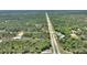 Distant aerial view showcases the property's location surrounded by a vast landscape of lush greenery and trees at 2971 Gardenia Dr, Indian Lake Estates, FL 33855