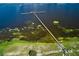 Aerial view of a long pier extending into a lake surrounded by lush greenery and aquatic plants at 2971 Gardenia Dr, Indian Lake Estates, FL 33855
