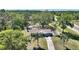 Scenic aerial view of a charming home surrounded by lush greenery, manicured landscaping, and a long driveway at 2971 Gardenia Dr, Indian Lake Estates, FL 33855