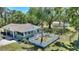 Aerial view of a home's backyard featuring a white picket fence, mature trees, and a comfortable outdoor seating area at 2971 Gardenia Dr, Indian Lake Estates, FL 33855
