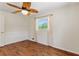 Bright bedroom featuring wood-look flooring, a window offering natural light, and a ceiling fan with decorative leaf blades at 2971 Gardenia Dr, Indian Lake Estates, FL 33855