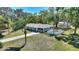 Beautifully landscaped property featuring a cozy home with a screened porch and a white picket fence at 2971 Gardenia Dr, Indian Lake Estates, FL 33855