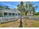 Charming home with a white picket fence, well-maintained lawn, and a separate outbuilding at 2971 Gardenia Dr, Indian Lake Estates, FL 33855