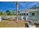 Cozy green home with a white picket fence and palm tree, ideal for Gathering living at 2971 Gardenia Dr, Indian Lake Estates, FL 33855