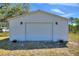 Exterior of the garage with a large door, perfect for vehicles and workshop projects at 2971 Gardenia Dr, Indian Lake Estates, FL 33855