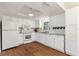 Bright kitchen featuring white cabinetry, modern appliances, granite countertops and wood flooring at 2971 Gardenia Dr, Indian Lake Estates, FL 33855