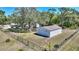 Exterior view of the metal outbuilding with a fenced in yard and lush green trees at 2971 Gardenia Dr, Indian Lake Estates, FL 33855