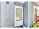 White door with glass panel on textured blue exterior wall offering a charming entryway at 4524 Oak Arbor Cir, Orlando, FL 32802