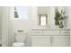 Clean bathroom featuring a modern vanity, well-lit mirror, and a combination of neutral colors at 4566 Ochos Rios Pl, Kissimmee, FL 34758