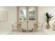 Elegant dining room with a modern table setting, large windows, and neutral tones at 4566 Ochos Rios Pl, Kissimmee, FL 34758